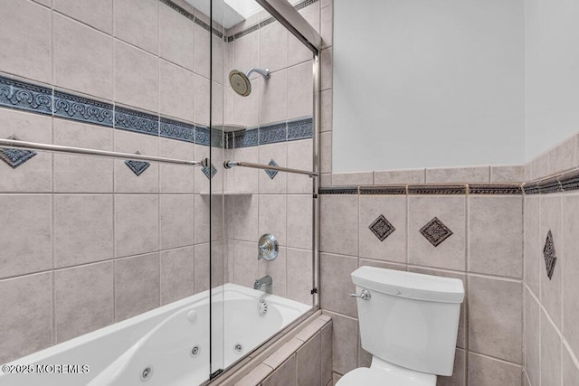 full bath featuring a combined bath / shower with jetted tub, tile walls, and toilet