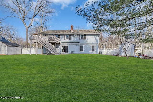 back of property featuring a storage shed, a fenced backyard, stairway, and an outdoor structure