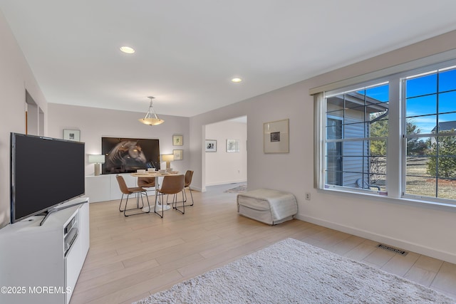 dining room featuring light wood-type flooring, baseboards, visible vents, and recessed lighting