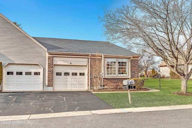 view of front facade featuring a garage, a front yard, brick siding, and driveway