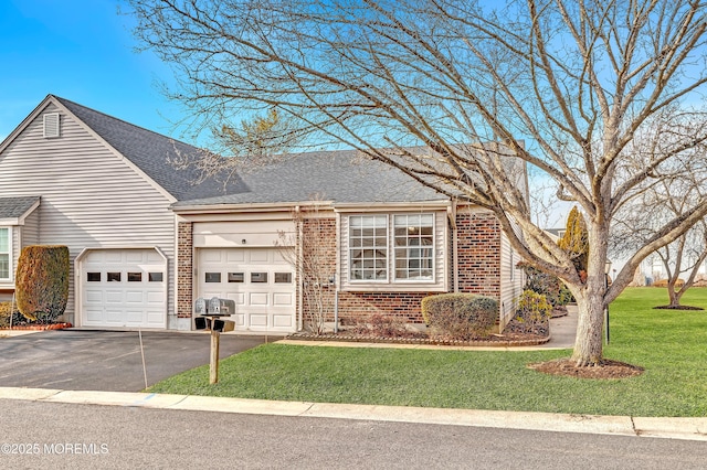 view of front of home with a garage, brick siding, driveway, and a front lawn