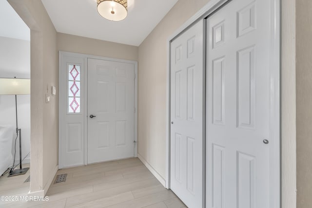entrance foyer with light wood-style floors, visible vents, and baseboards