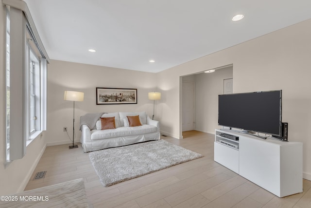 living area featuring light wood-style flooring, visible vents, baseboards, and recessed lighting
