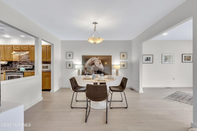dining space featuring light wood-type flooring, baseboards, and recessed lighting