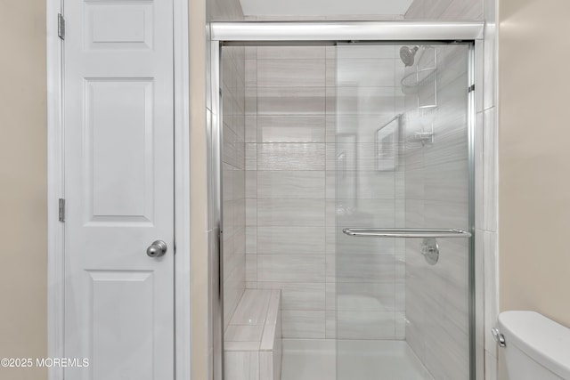 bathroom featuring a shower stall and toilet