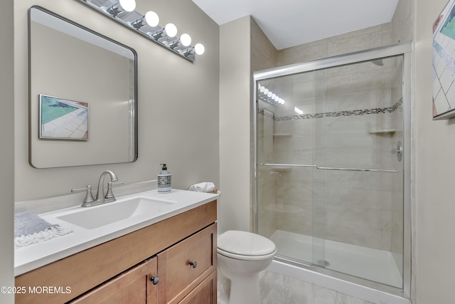 bathroom featuring a shower stall, toilet, and vanity