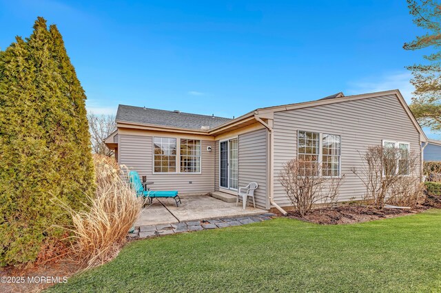 rear view of property featuring a lawn and a patio area