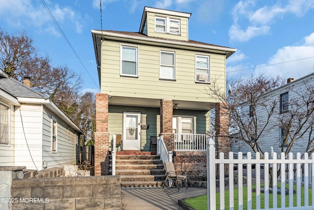 view of front of home with a porch, brick siding, and fence