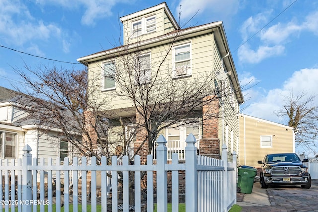 american foursquare style home featuring a fenced front yard