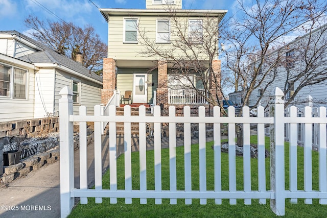 view of front of home featuring a fenced front yard, a porch, and brick siding