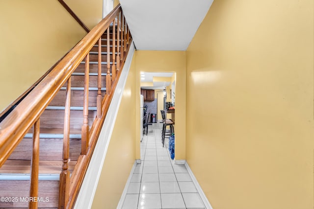 stairs featuring tile patterned flooring and baseboards