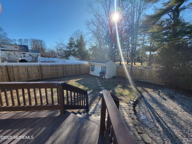 wooden deck featuring a fenced backyard and an outdoor structure