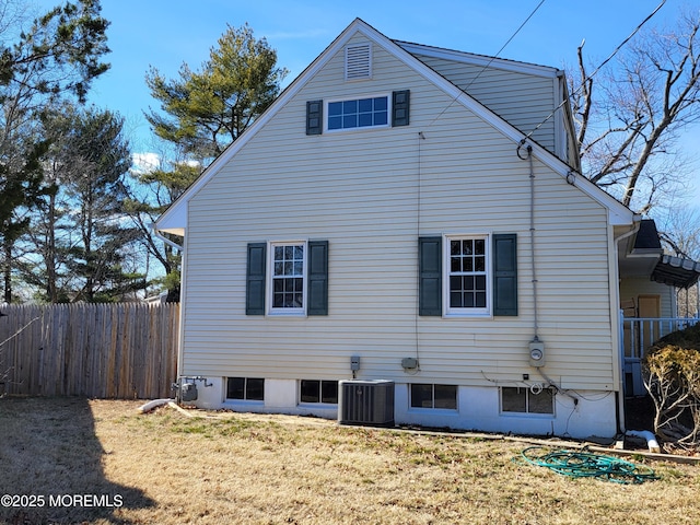 view of side of property featuring central AC, a yard, and fence