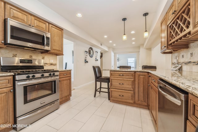 kitchen with a peninsula, brown cabinets, stainless steel appliances, and hanging light fixtures