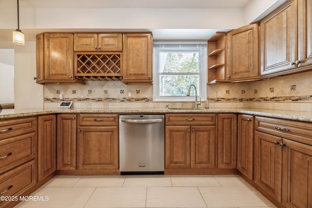 kitchen featuring brown cabinets, a sink, stainless steel dishwasher, and light stone countertops