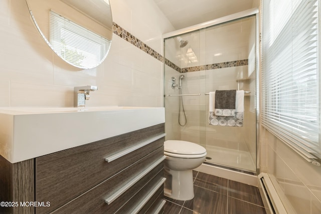 bathroom featuring a stall shower, tile walls, toilet, and a baseboard radiator