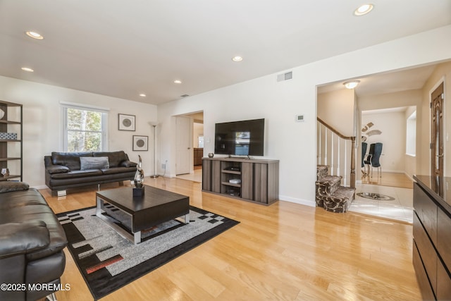 living room featuring light wood finished floors, stairway, visible vents, and recessed lighting