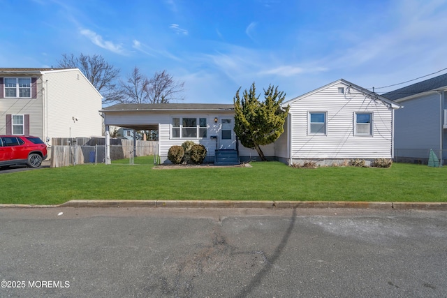 view of front of property featuring a carport, entry steps, fence, and a front lawn