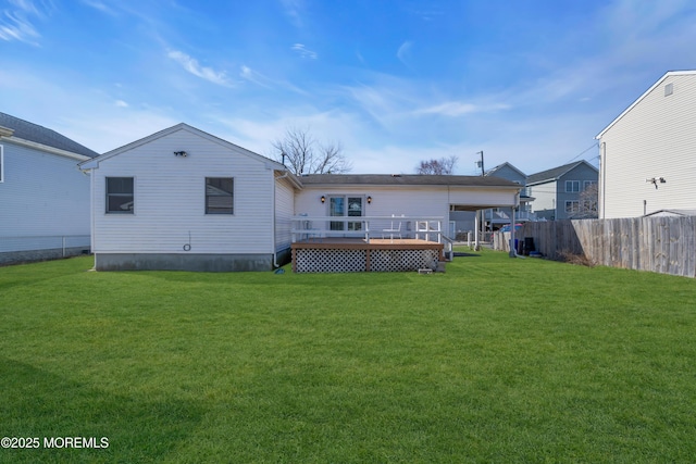 back of house with a wooden deck, fence, and a yard