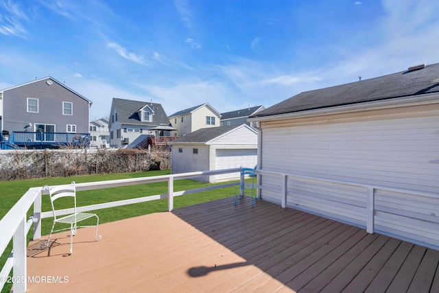 wooden terrace with a residential view, a yard, and an outbuilding