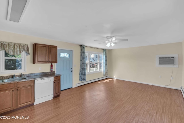 kitchen featuring light wood finished floors, dishwasher, baseboard heating, a sink, and a wall mounted AC