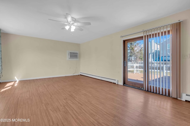 spare room with baseboards, a ceiling fan, wood finished floors, a wall mounted air conditioner, and a baseboard heating unit