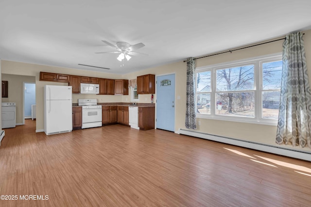 kitchen with white appliances, washer / dryer, a ceiling fan, baseboard heating, and light wood-type flooring