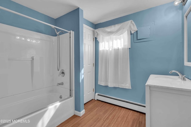 bathroom with  shower combination, baseboard heating, wood finished floors, and vanity