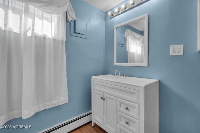 bathroom featuring a baseboard heating unit, vanity, and wood finished floors