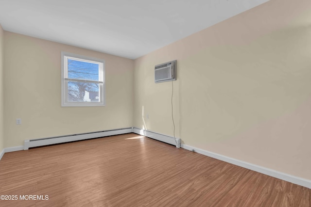 empty room with a wall unit AC, a baseboard radiator, baseboards, and wood finished floors