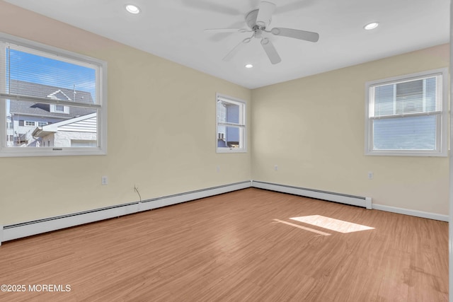 unfurnished room with a baseboard radiator, a healthy amount of sunlight, recessed lighting, and wood finished floors