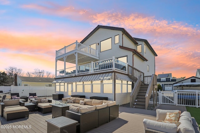 back of property with stairway, an outdoor hangout area, a wooden deck, and a gate