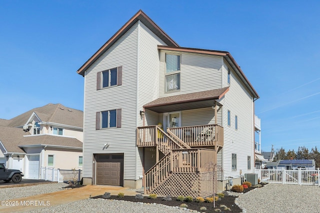 view of front of house featuring central air condition unit, a gate, fence, stairway, and a garage