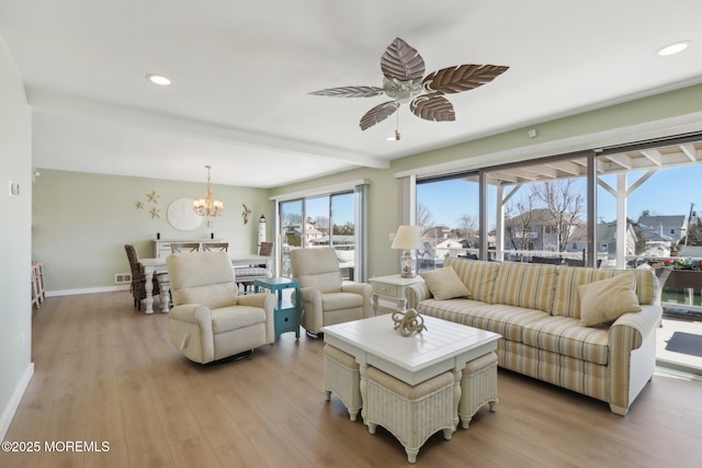 living room with visible vents, baseboards, light wood-style flooring, recessed lighting, and ceiling fan with notable chandelier