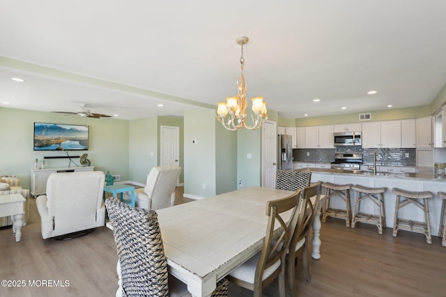 dining space featuring recessed lighting, visible vents, ceiling fan with notable chandelier, and light wood finished floors