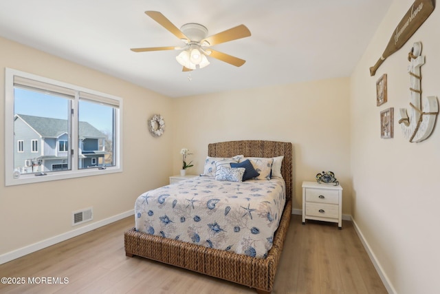 bedroom with visible vents, baseboards, and wood finished floors