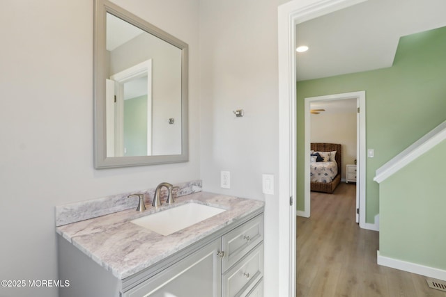 bathroom with vanity, wood finished floors, and baseboards