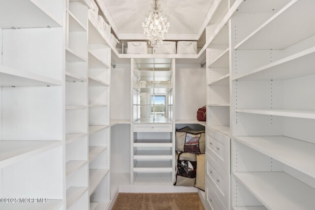 walk in closet featuring an inviting chandelier