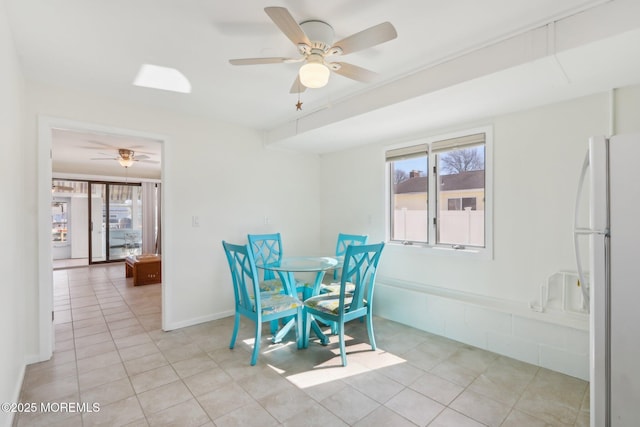 unfurnished dining area featuring plenty of natural light, baseboards, light tile patterned floors, and ceiling fan