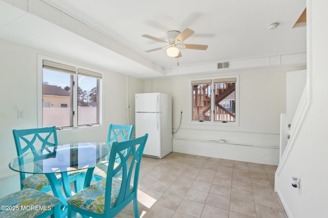 dining room with light tile patterned floors, visible vents, and ceiling fan