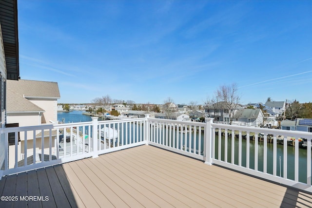 wooden terrace featuring a residential view and a water view