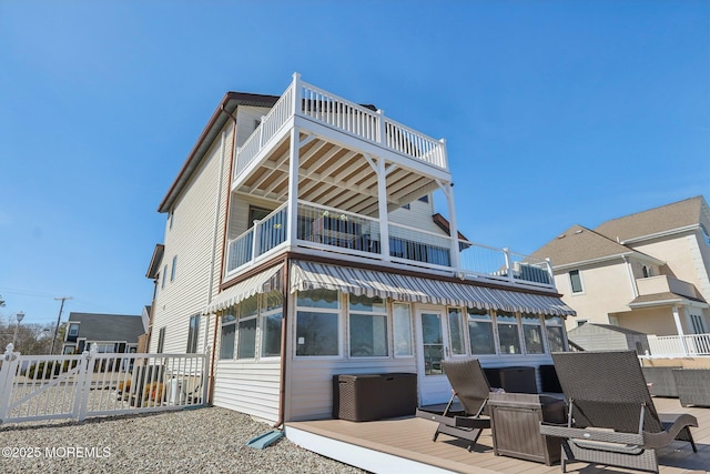 back of house featuring a wooden deck, a balcony, and fence