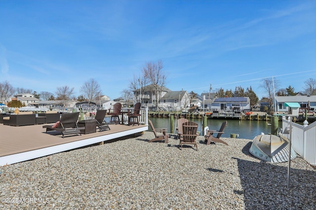 view of dock with a water view, a residential view, and an outdoor fire pit