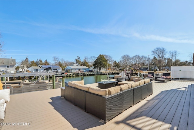 deck featuring a residential view, outdoor lounge area, a dock, and a water view