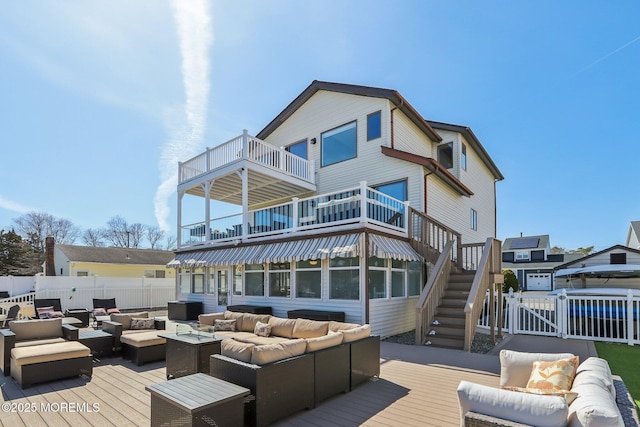 rear view of house with stairway, a gate, fence, an outdoor living space with a fire pit, and a deck