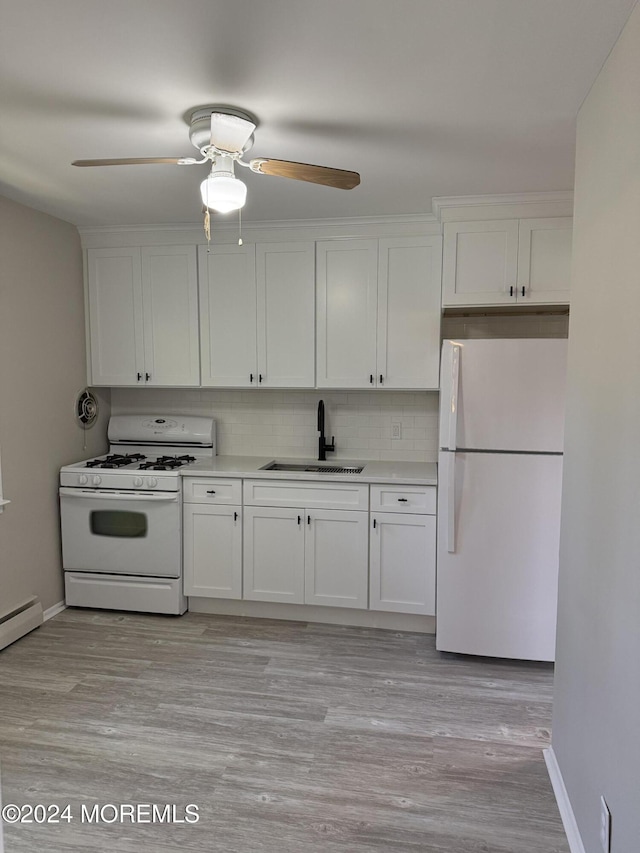 kitchen with white appliances, white cabinets, and a sink