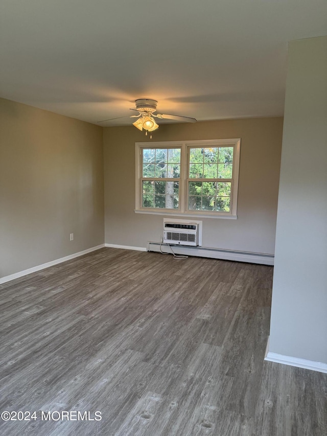 unfurnished living room with an AC wall unit, wood finished floors, a ceiling fan, and baseboards