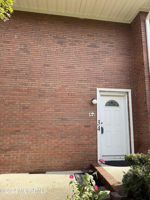 entrance to property featuring brick siding