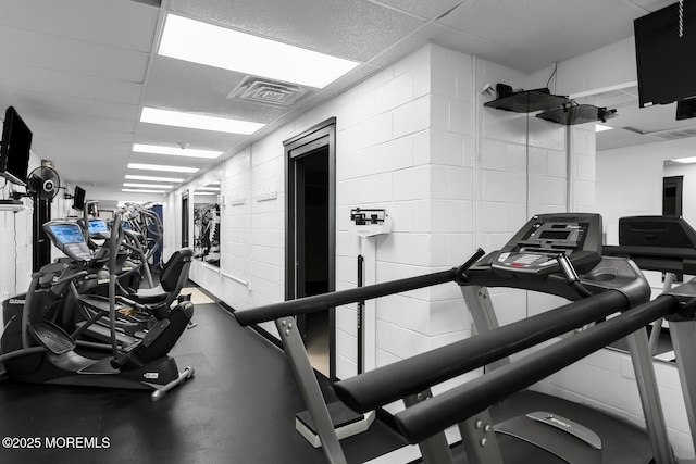 gym with a paneled ceiling and visible vents