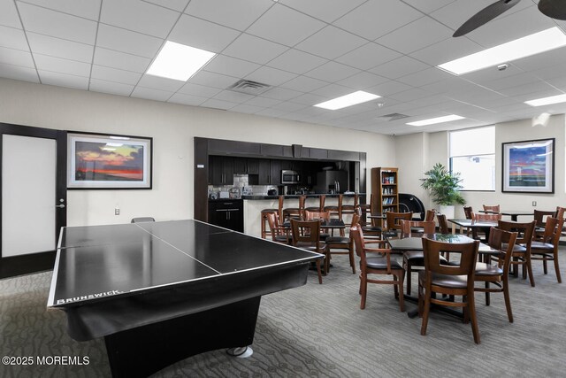 recreation room featuring a paneled ceiling, visible vents, and carpet floors